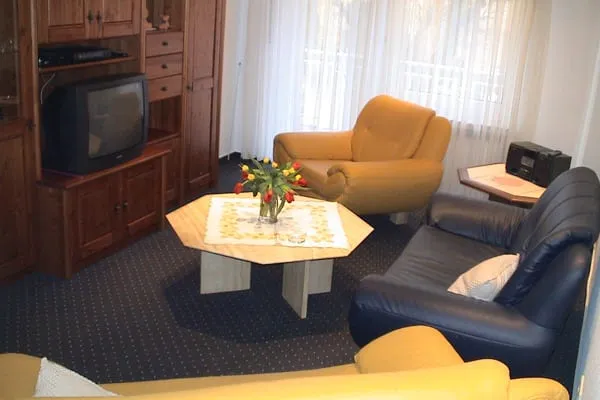 Wohnzimmer mit Sesseln, Sofa und kleinem Tisch